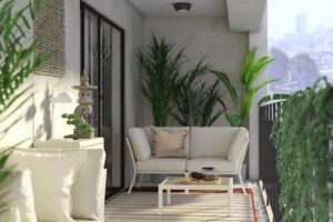 Balcón cubierto con sofá blanco al fondo, mesa baja y plantas junto a la barandilla